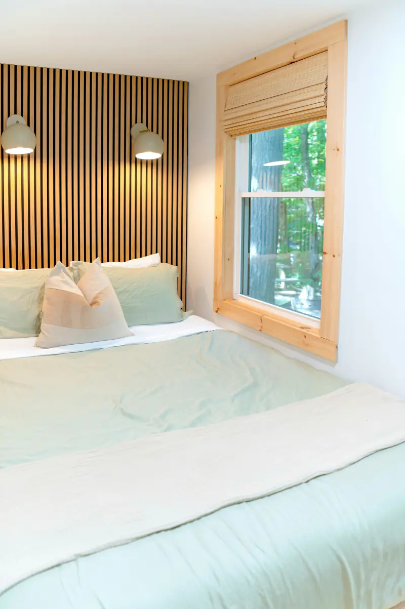 Einzelzimmer mit hellem Holz und Fenster zu den Bäumen