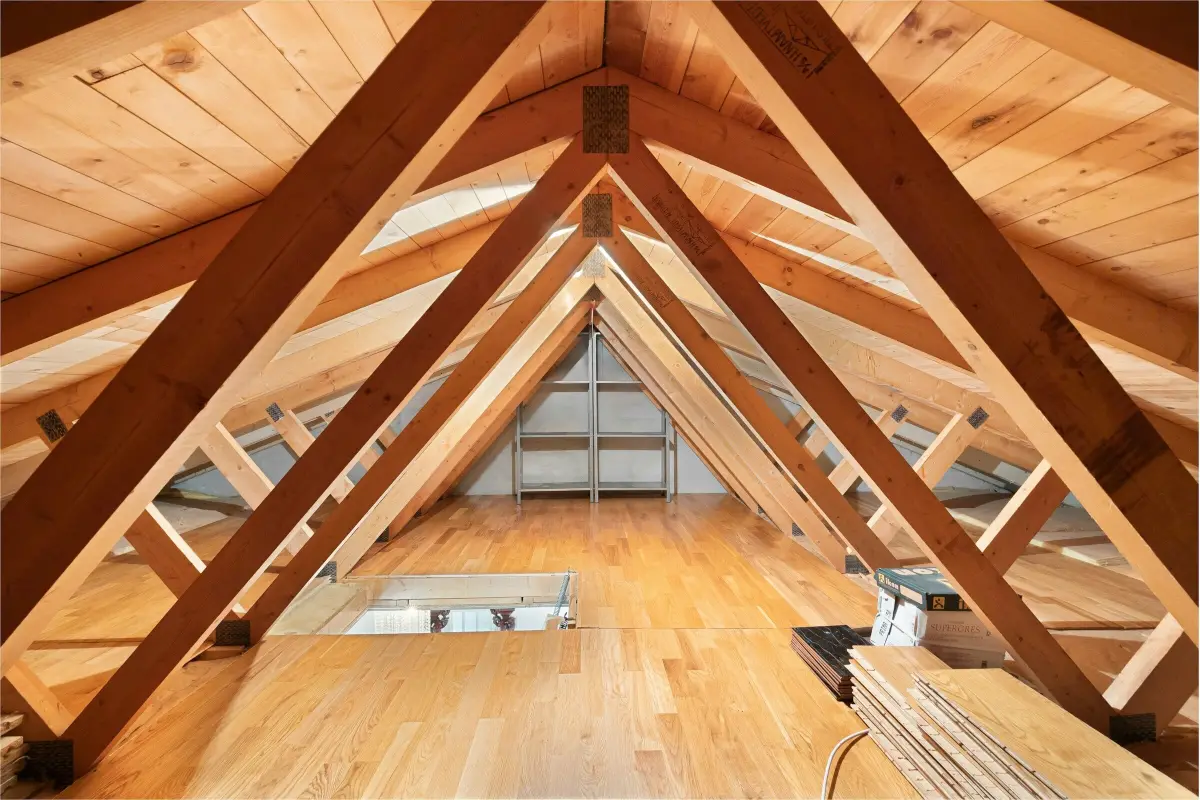 Ausgebauter Dachboden mit sichtbaren Holzbalken und Dielenboden