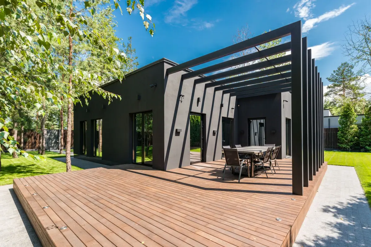Große Holzterrasse mit Pergola vor einem modernen Haus